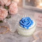 Load image into Gallery viewer, Blue rose-shaped candle in a decorative holder with flowers and a card in the background
