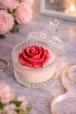 Load image into Gallery viewer, Decorative glass container with a red rose on a marble surface with flowers and ribbon in the background.
